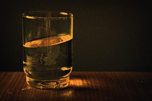 A glass of water lit in amber